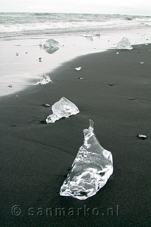 Glanzende ijsblokken op het git zwarte strand bij Jökulsárlón