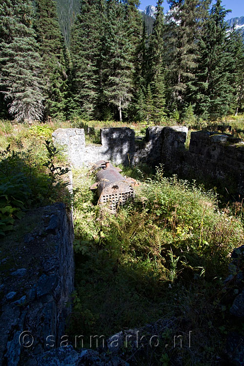 Een oude stoom boiler in de ruines van het hotel in Glacier NP