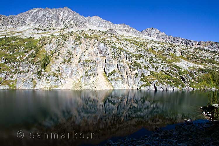 De mooie weerspiegeling van de rotsen in Kokanee Lake