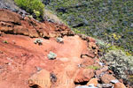Een steile afdaling over een knal rood wandelpad naar Punta del Hidalgo op Tenerife