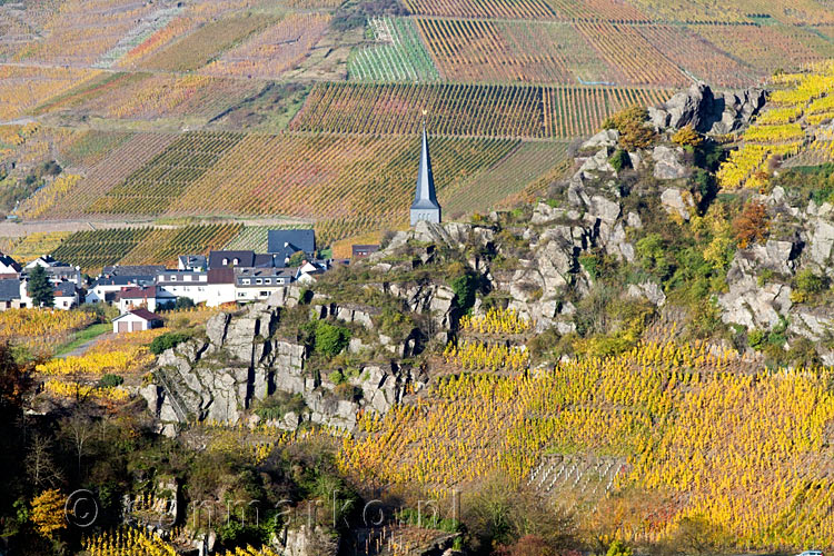 Achter de rotsen de kerk van Mayschoß vanaf de Rotweinwanderweg in het Ahrtal