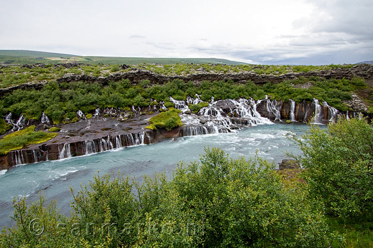 Vanaf de parkeerplaats het uitzicht over de brede Hraunfossar in IJsland