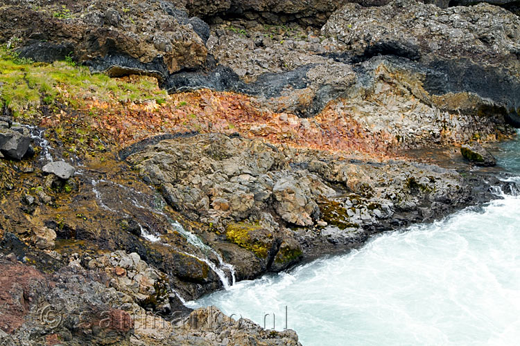 De verschillende lagen lava, grond en mineralen bij de Hraunfossar