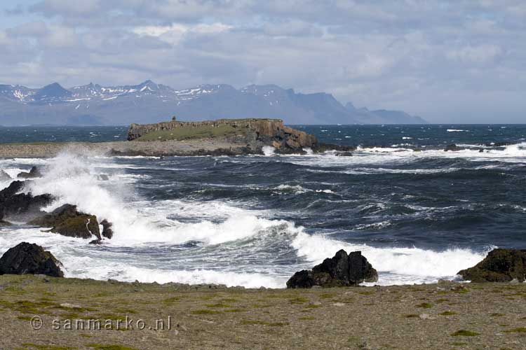 Golven beuken op rotsen in de zee bij Djúpivogur in IJsland