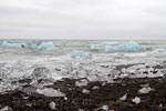 Het gitzwarte zand bij Jökulsárlón is bezaaid met ijsblokken