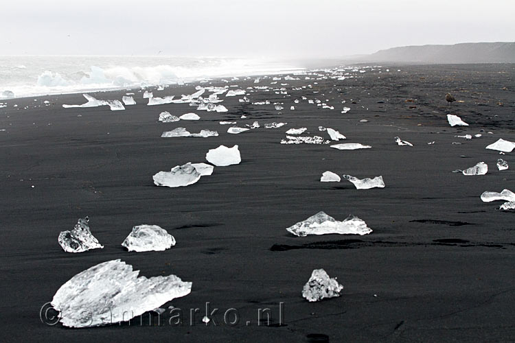 Het strand waar het gletsjermeer Jökulsárlón de zee in stroomt