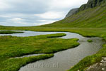 De rivier die door het midden van Kaldbaksdalur stroomt van de waterval naar het fjord op de Westfjorden