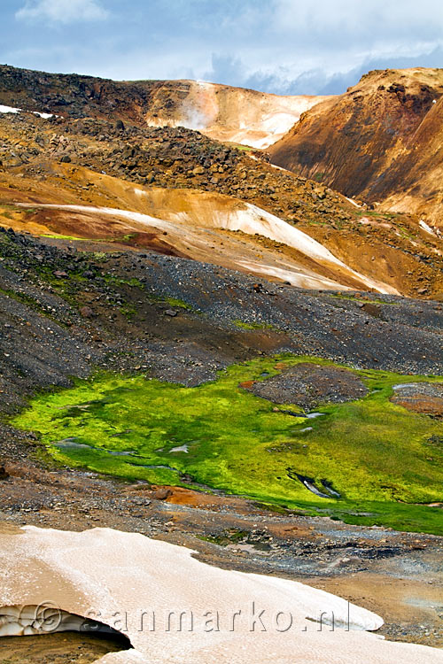 Gif groen mos in contrast met zwarte lava en gele bergen in Kerlingarfjöll