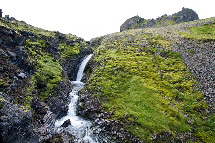 Het contrast van groen en zwart bij de Klukkufoss Klokwaterval op IJsland