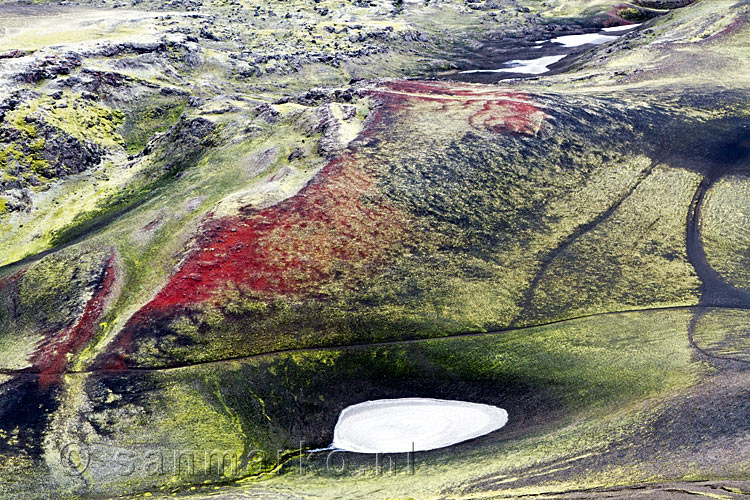 De typische rode kleur van Ljótipollur tussen groen in Landmannalaugar