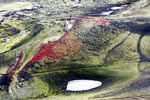 De typische rode kleur van Ljótipollur tussen groen in Landmannalaugar