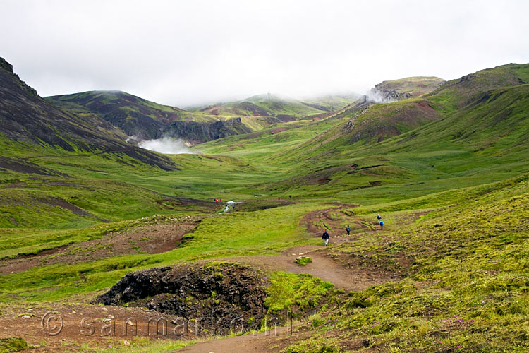 Uitzicht over het modderige wandelpad en Reykjadalur bij Hveragerði in IJsland