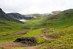 Uitzicht over het modderige wandelpad en Reykjadalur bij Hveragerði in IJsland