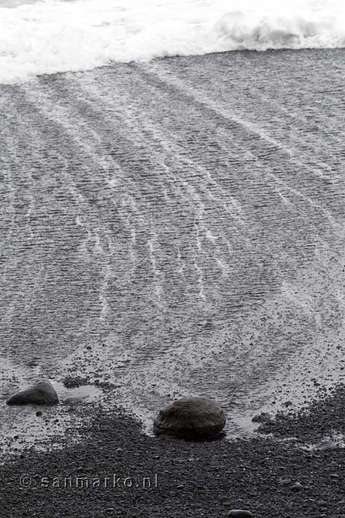 De golven over het strand bij Reynisfjara zijn zeer rustigevend bij Vík