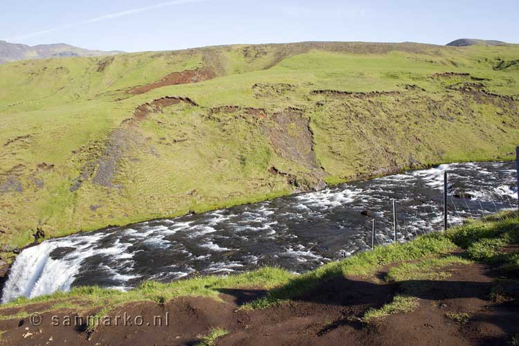 Na een lange trap het uitzicht boven op de Skógafoss waterval in IJsland