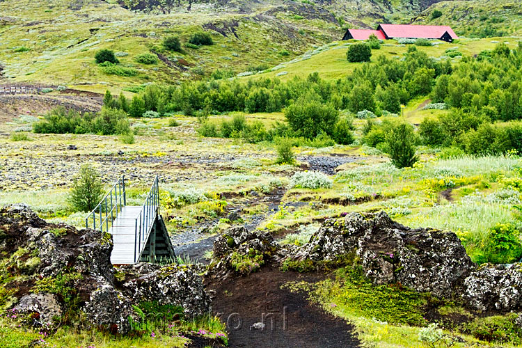 De brug met in de achtergrond de loods van Stöng in IJsland