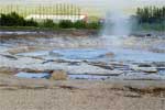 Een nog rustige Strokkur geiser bij Geysir in de Golden Circle