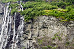 Naast de waterval oude boerderijen in het Geirangerfjord in Noorwegen