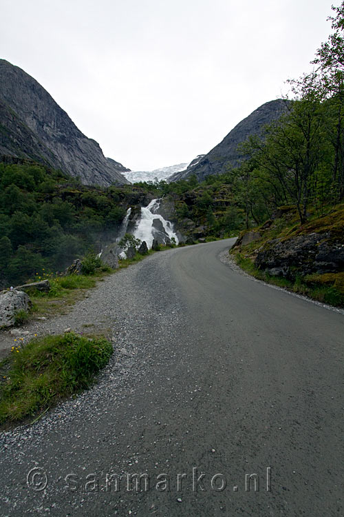 Wandelen over een brede weg met uitzicht op de Kleivafossen en de Briksdalsbreen