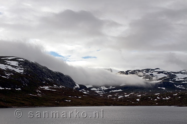 Wolken komen over de bergen bij het meer Tyin bij Tyin-Filefjell