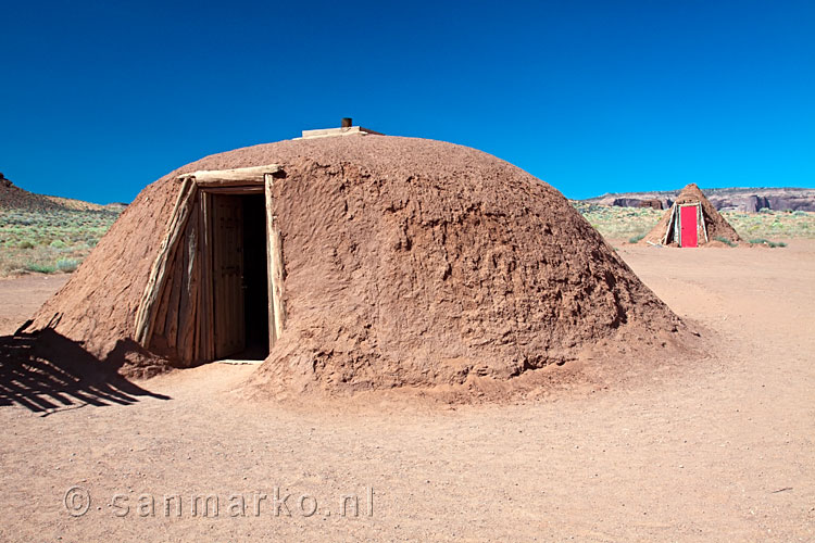 Een vrouwen (voorgrond) en een mannen Hogan in Monument Valley